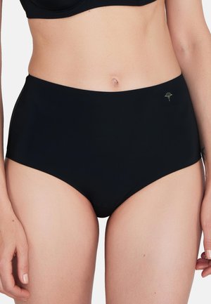 Vrouw die zwarte slips met hoge taille en bijpassende beha draagt, waarbij de buik en bovenbenen zichtbaar zijn tegen een effen witte achtergrond.