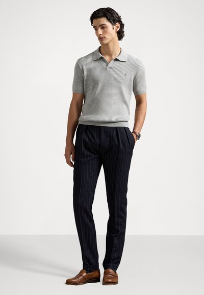 Grijze geribbelde polo met kraag, gecombineerd met marineblauwe gestreepte broek en bruine leren schoenen. Ontworpen voor een aansluitende look.