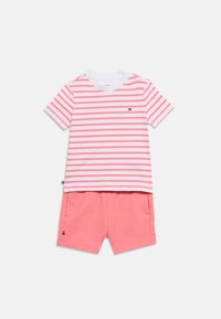 Κοντομάνικο πουκάμισο με λευκές και ροζ ρίγες και μικρό λογότυπο, συνδυασμένο με μονόχρωμα ροζ σορτς με πλαϊνές τσέπες και λεπτομέρειες λογότυπου.