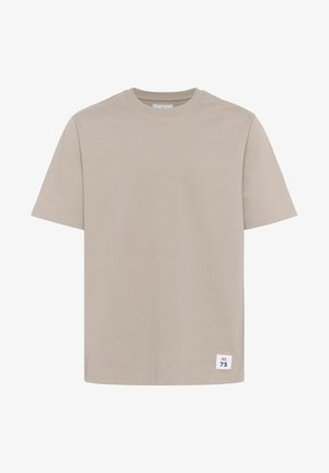 Bež majica iz bombaža s kratkimi rokavi, okroglim izrezom in majhno belo oznako z napisom "M 73" v spodnjem levem kotu.