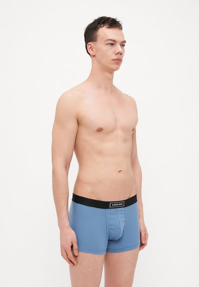 Boxeri berna de culoare albastră, fabricati dintr-un material texturat, cu o bandă elastică neagră pe talie, care include detalii cu logo și un design suportiv pentru partea frontală.