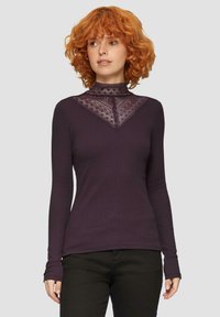 Langärmliges lila Oberteil mit einem V-förmigen Spitzenüberzug am Ausschnitt, aus weichem Material mit taillierten Ärmeln.