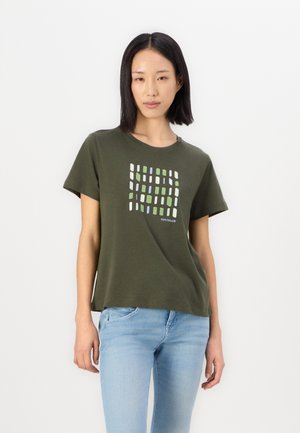 T-shirt vert olive à manches courtes avec un motif géométrique blanc et coloré sur le devant, fabriqué en tissu de coton doux, au design décontracté.