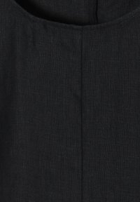 Schwarzer Leinenstoff mit einer dezenten Textur, der eine glatte Oberfläche und saubere, vertikale Nähte entlang der Naht aufweist.