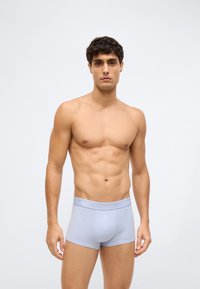 Světle modré bavlněné boxerky s šedým elastickým pasem, na kterém je logo "Calvin Klein". Hladký povrch a přiléhavý střih.