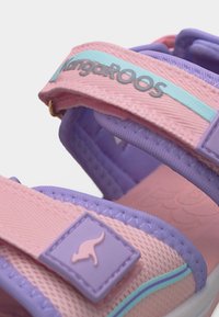 Παιδικό σανδάλι σε ροζ και μωβ χρώμα με ρυθμιζόμενα λουριά, λογότυπο Kangaroos στο λουρί και εικονίδιο καγκουρό στο μπροστινό λουρί.