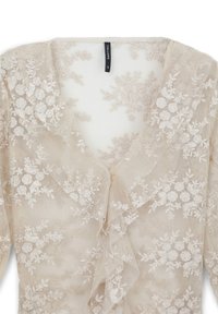 Beige Spitze Bluse mit floralem Stickerei, tiefem V-Ausschnitt und gerafften Kanten. Das Material scheint leicht und strukturiert zu sein. Größenetikett sichtbar.