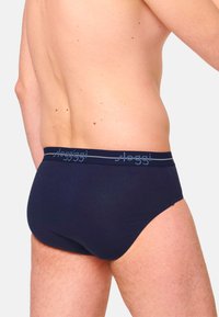 Dunkelblaue Herrenunterhose mit weichem Stretchmaterial, elastischem Bund mit Markenlogo und einem klassischen Schnitt, der den Körperkonturen folgt.