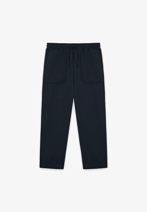 Pantaloni con vita elastica nera, coulisse e grandi tasche applicate anteriori, taglio a gamba dritta.