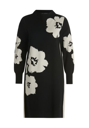 Czarna dzianinowa sukienka z długimi rękawami, z dużymi białymi kwiatowymi wzorami. Posiada wysoki dekolt i boczne rozcięcia dla swobody ruchów.