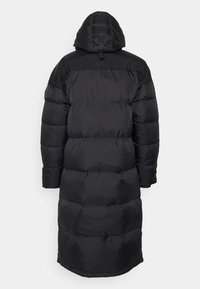 Svart puffjacka med huva, med en quiltad design. Långa, puffiga ärmar och knälång längd ger värme och täckning.