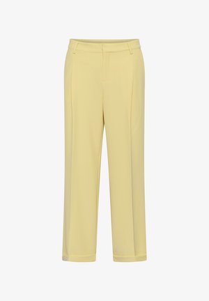 Gaiši dzelteni piegriezti bikses ar jostas cilpām, priekšējo locījumu un apakšmalu ar aprocēm uz balta fona.