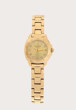 Reloj de pulsera de metal dorado con correa enlazada, esfera redonda, marcadores de hora de cristal y el nombre de la marca Coach New York en la esfera.