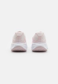Light pink athletic shoes with breathable mesh upper, padded heel, and white cushioned sole featuring a textured pattern for traction.