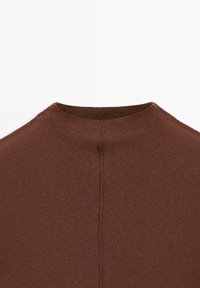 Braun geripptes Strickoberteil mit hohem Kragen und einer Naht, die entlang der Mitte des Rückens verläuft. Weiche Textur, minimalistisches Design und keine sichtbaren Verzierungen.