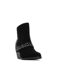 Botas de tobillo de ante negro con forma cónica, que presentan acentos de tachuelas plateadas alrededor del tobillo y un tacón bajo y apilado.