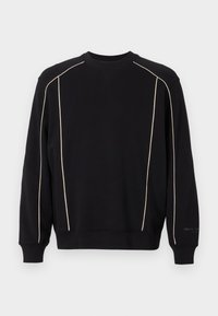 Μαύρη μπλούζα με μακριά μανίκια, που διαθέτει κρεμ ραφές στους ώμους και τα πλάγια. Ριμπ μανίκια και λαιμόκοψη, μαλακή υφή.