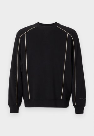 Melns sporta krekls ar garām piedurknēm, kuram ir krēmkrāsas šuvju apdare plecos un sānos. Ribu kakls un aproces, mīksta tekstūra.