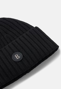 Czarna, prążkowana czapka typu beanie z odstającym mankietem, z okrągłą czarną naszywką i srebrnym emblematem litery "B".