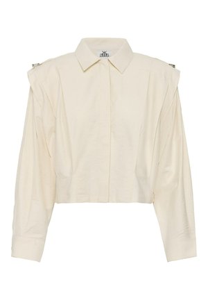 Cremefarbenes, langärmliges, kurz geschnittenes Hemd mit spitzem Kragen, verdeckten Vorderknöpfen und gerafften Schultern mit kleinen silbernen Verschlüssen.