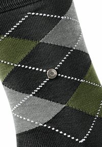 Skarpetki w wzór argyle w kolorze czarnym, szarym i oliwkowym, z białymi przeszyciami i małym metalowym akcentem z logo.