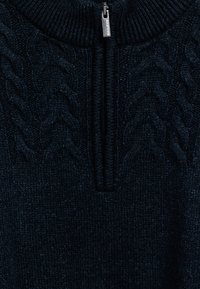 Donker marineblauwe gebreide trui met een halve rits kraag en een gevlochten kabelbreipatroon aan de voorkant.