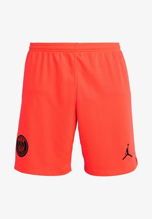 Shorts de sport orange vif avec une taille élastique, arborant le logo du Paris Saint-Germain sur la jambe gauche et le logo Jumpman noir sur la jambe droite.