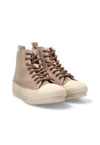 Par de zapatillas altas beige con suelas gruesas en color crema y cordones marrones, ligeramente inclinadas hacia la derecha sobre un fondo blanco.