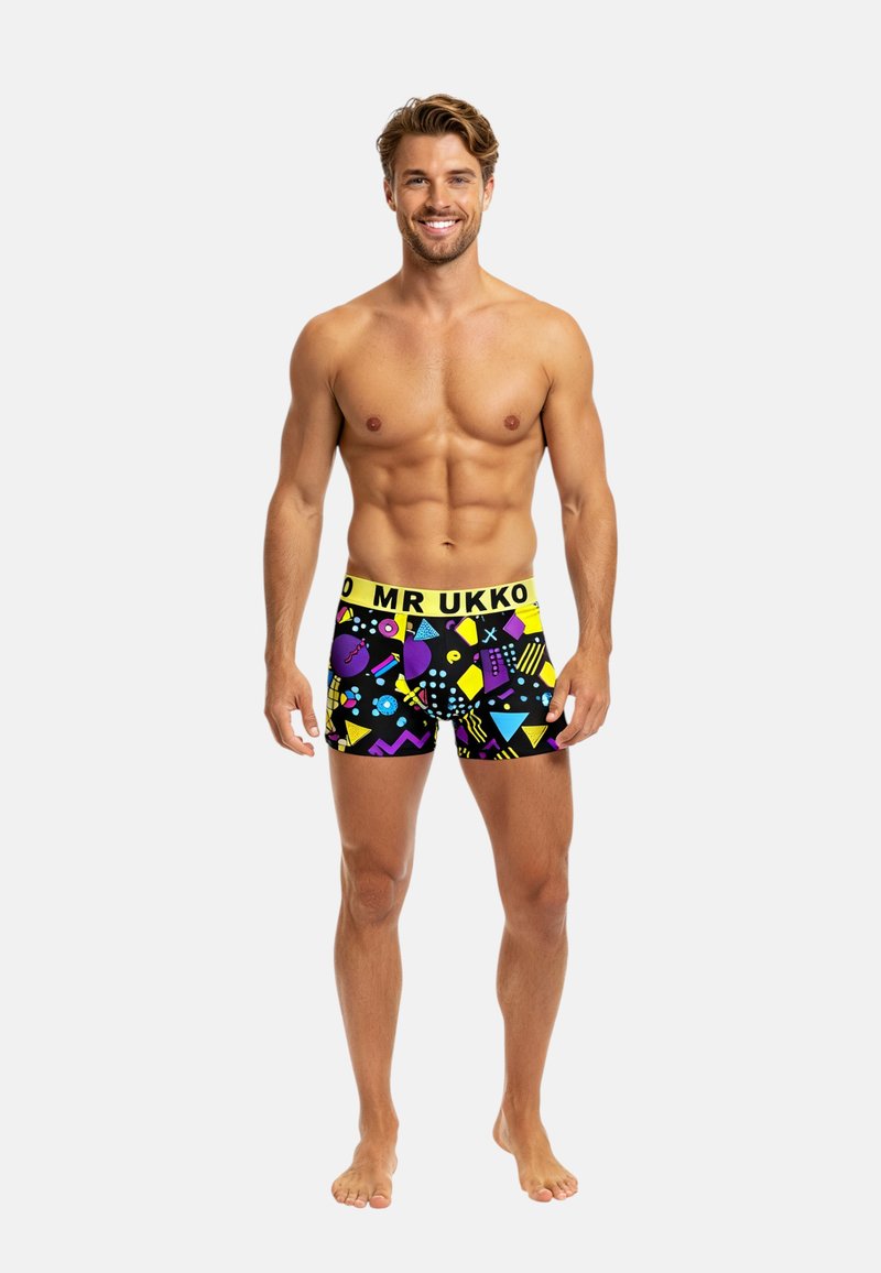 Boxer shorts neri con motivi geometrici colorati. Presentano un elastico giallo con la scritta "MR UKKO". Tessuto morbido, design aderente.