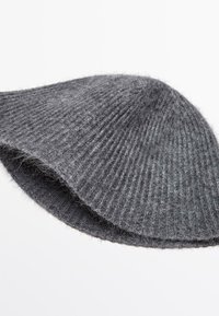 Cappello grigio lavorato a maglia con forma arrotondata, realizzato in morbida lana. Caratterizzato da una texture a coste e un design senza cuciture, offre calore e comfort.
