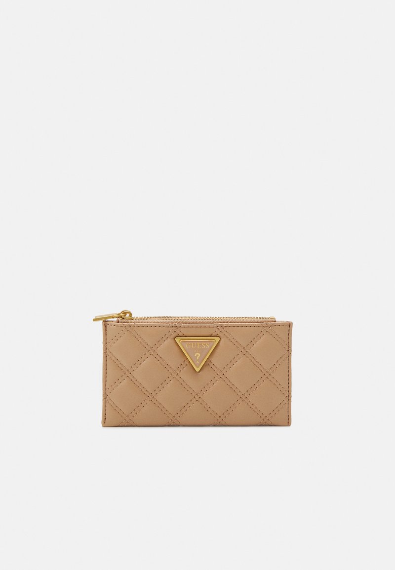 Tan quilted portemonnee met gouden hardware en een driehoekig logo. Voorzien van een ritssluiting, een soepele textuur en een diagonaal stikpatroon.