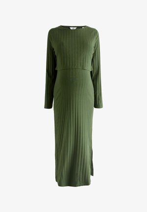 Gara, olīvu zaļa ribota kleita ar apaļu kakla izgriezumu un garām piedurknēm, aprīkota ar piegulošu augšdaļu un platāku svārku ar sānu šķēlumu.