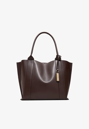 Sac fourre-tout en cuir marron foncé avec deux bretelles et une étiquette dorée attachée à une des bretelles.