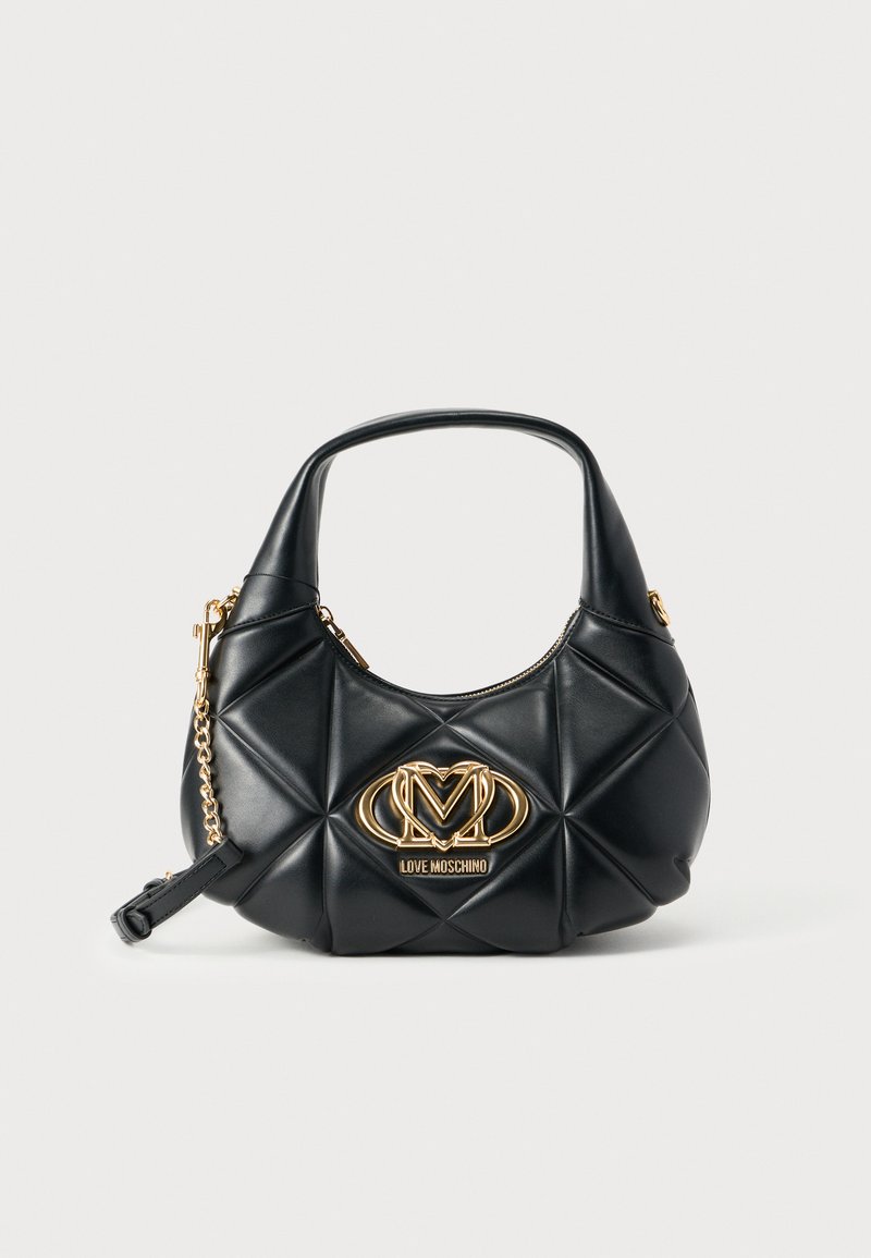Μαύρη τσάντα χειρός από συνθετικό δέρμα με καπιτονέ υφή και στρογγυλεμένο σχήμα. Διαθέτει χρυσό λογότυπο και αλυσίδα ως διακοσμητικό στοιχείο, καθώς και κοντή λαβή. Κλείσιμο με φερμουάρ.