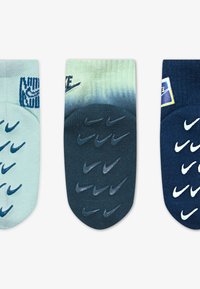 Tres pares de calcetines: el izquierdo en azul claro, el del medio en azul oscuro con un degradado, y el derecho en azul marino con logotipos blancos de Nike y características de agarre.
