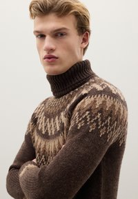 Brown wool turtleneck sweater featuring a textured geometric pattern in light tan and darker brown shades. High ribbed collar.
