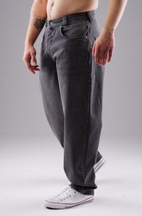 Graue Jeans aus Denim mit einer lockeren Passform, mit Kupferakzenten, fünf Taschen und einem Reißverschluss. Kombiniert mit weißen Sneakers.