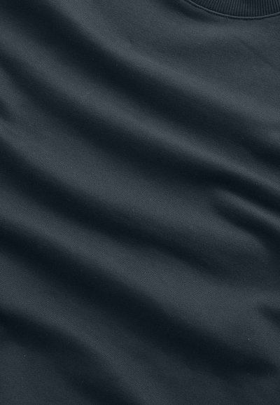 Dark gray fabric with soft folds and fine knit texture, highlighting smooth material and subtle shading variations.