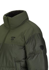 Groene pufferjack met hoge kraag, ritssluiting en logo-detail. Beschikt over een mix van matte en glanzende texturen. Zwarte accentpatch op de mouw.