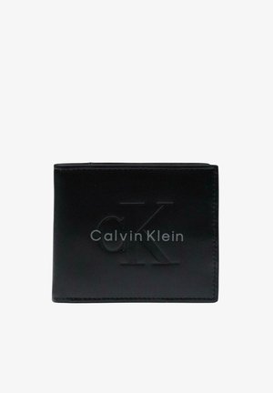 Cartera negra de piel plegable con el logotipo "cK" y el texto Calvin Klein en relieve en el frente, cerrada y centrada sobre fondo blanco.