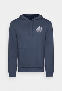 Mörkblå hoodie gjord av mjukt tyg, med en framficka i kangoorustil, ribbade muddar och en vit grafisk logotyp på vänster bröst.