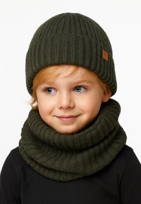 Green ribbed knit beanie and matching infinity scarf, both made of soft material, featuring a seam detail and a small branded tag.