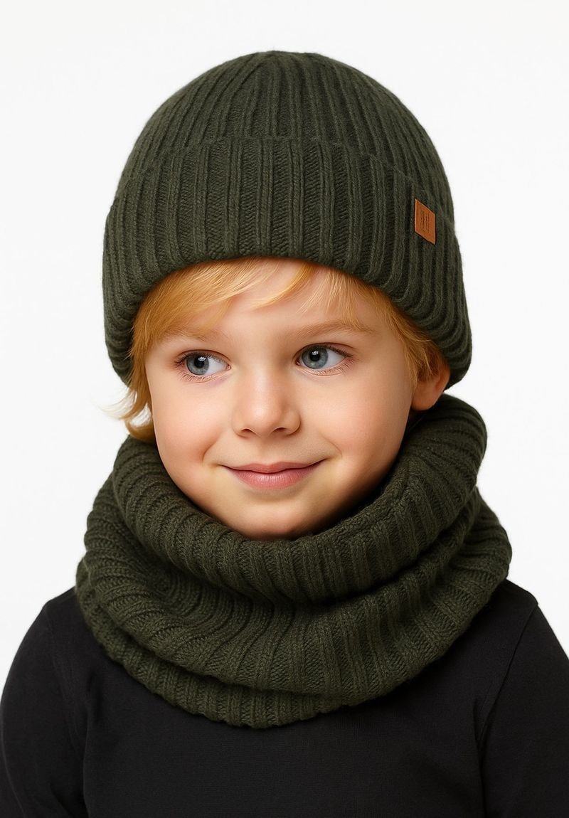 Green ribbed knit beanie and matching infinity scarf, both made of soft material, featuring a seam detail and a small branded tag.