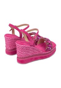 Sandales à talons compensés rose avec une semelle en jute tressée, des accents de bijoux sur les brides et une texture en daim doux. Brides de cheville réglables incluses.