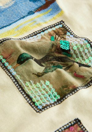 Material bej cu un design texturat ce prezintă paiete verzi aranjate într-un model în jurul unei imagini imprimate a unei rațe pe un fundal estompat.