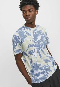 Kortärmad t-shirt i ljusgröna tyget med blå blommönster. Har rund halsringning och avslappnad passform.