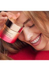 Il barattolo della crema Merveillance LIFT presenta un design oro e rosso-rosa sfumato, con testo che descrive le sue proprietà idratanti e ingredienti chiave.