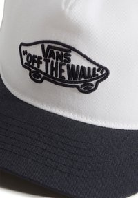 Gorra de tela blanca y azul marino con visera curva, que presenta "VANS OFF THE WALL" bordado en negro en la parte frontal con un diseño gráfico.