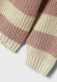 Maglione a righe in rosa polveroso e crema, con texture a coste, tessuto spesso e un piccolo etichetta sul polsino sinistro.
