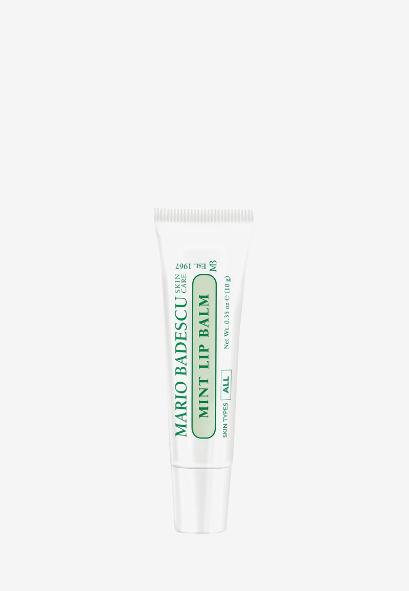 Tube blanc de 10g de baume à lèvres Mint de Mario Badescu avec du texte vert. Dispose d'un embout à presser pour une application facile. Convient à tous les types de peau.